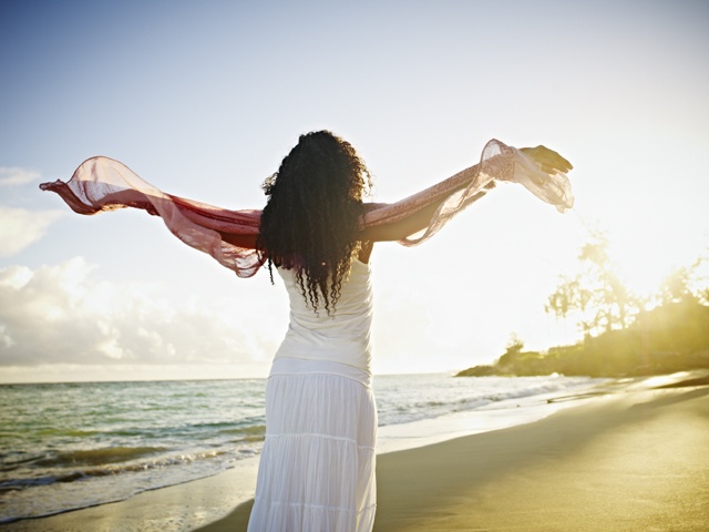 Woman with arms outstretched towards sun