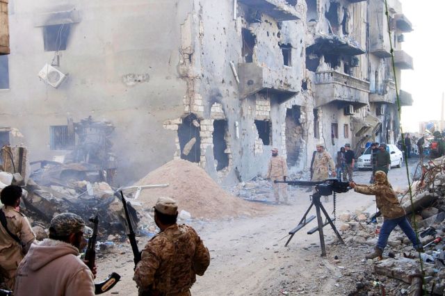 Members of the Libyan pro-government forces, backed by the locals, with weapons are seen during clashes in the streets with Shura Council of Libyan Revolutionaries in Benghazi